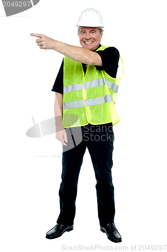 Image of Cheerful estate engineer indicating sideways