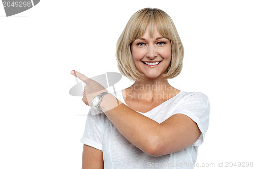 Image of Smiling woman pointing backwards