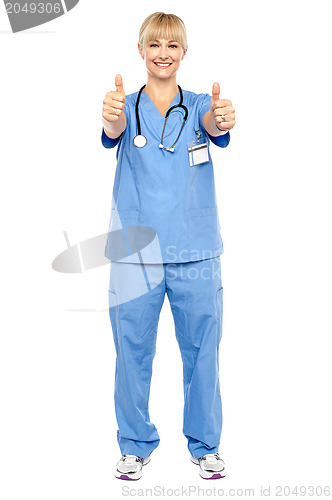 Image of Cheerful lady doctor showing double thumbs up