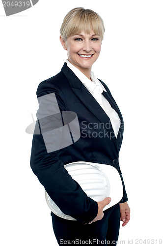 Image of Cheerful female architect holding hardhat
