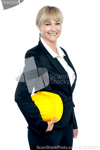 Image of Pretty business architect with yellow safety helmet in hand