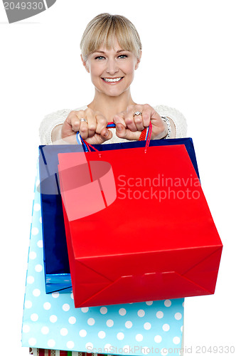 Image of Woman holding shopping bags in her outstretched arms