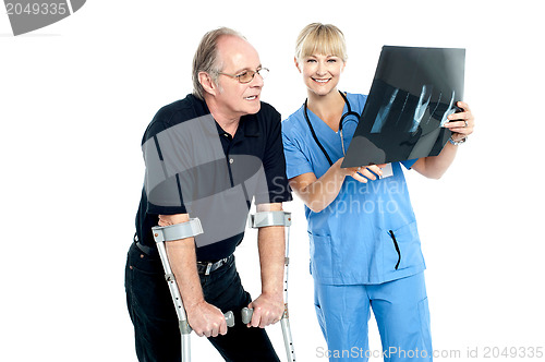 Image of Surgeon showing x-ray sheet to her patient