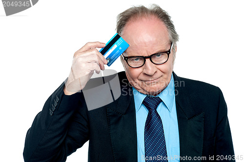 Image of Businessman scratching his forehead with plastic card