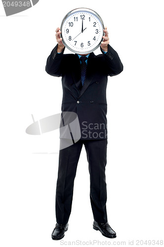 Image of Executive holding up wall clock in front of his face