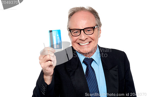 Image of Old man wearing eyeglasses holding up a cash card