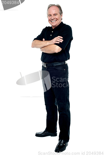 Image of Happy man in black attire posing with arms folded