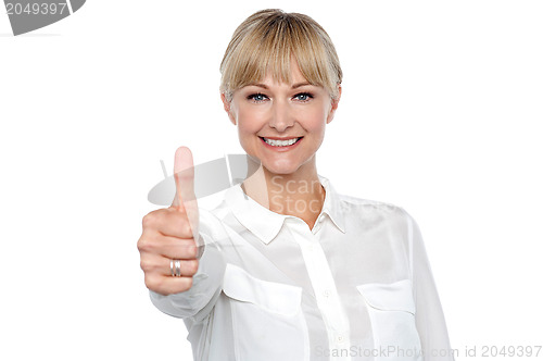 Image of Blonde woman in formal attire showing thumbs up gesture
