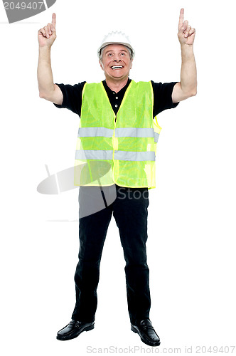 Image of Experienced construction employee pointing his fingers upwards