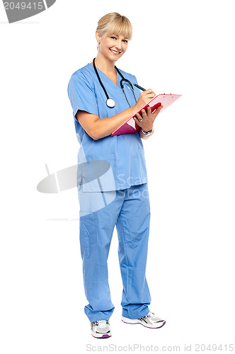 Image of Smiling nurse preparing case sheet of a patient