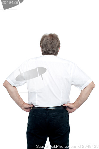 Image of Back pose of a senior man standing with hands on his waist