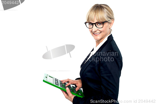 Image of Bespectacled entrepreneur using a calculator