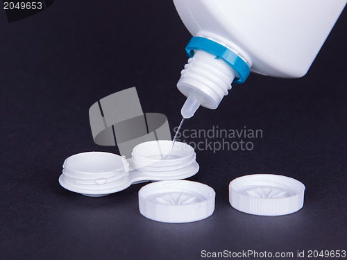 Image of Lens casing and bottle of water isolated on black