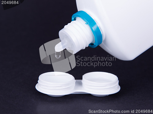 Image of Lens casing and bottle of water isolated on black