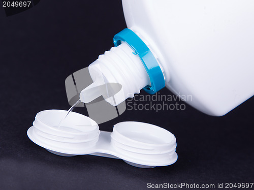 Image of Lens casing and bottle of water isolated on black