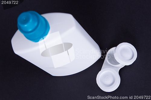 Image of Lens casing and bottle of water isolated on black
