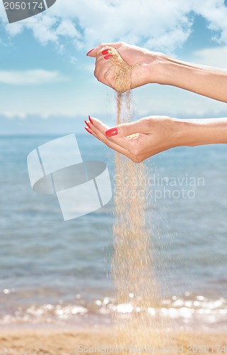 Image of Hands and sand on the beach