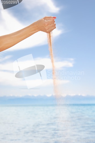 Image of Woman hand playing with sand