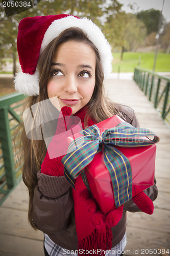 Image of Pretty Woman Wearing a Santa Hat with Wrapped Gift