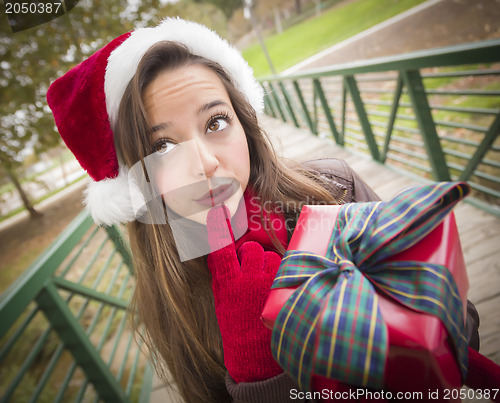 Image of Pretty Woman Wearing a Santa Hat with Wrapped Gift