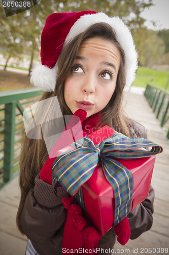 Image of Pretty Woman Wearing a Santa Hat with Wrapped Gift