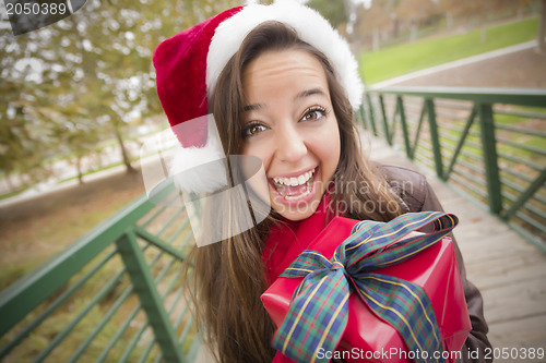 Image of Pretty Woman Wearing a Santa Hat with Wrapped Gift