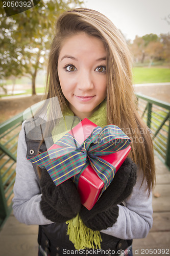 Image of Pretty Woman with Wrapped Gift with Bow Outside