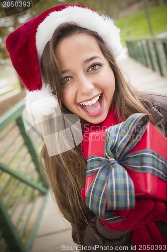 Image of Pretty Woman Wearing a Santa Hat with Wrapped Gift