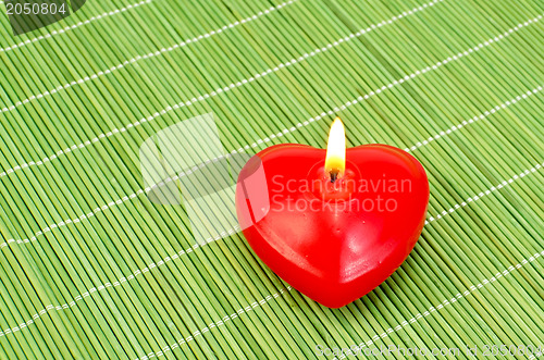 Image of Heart of red candles on bamboo