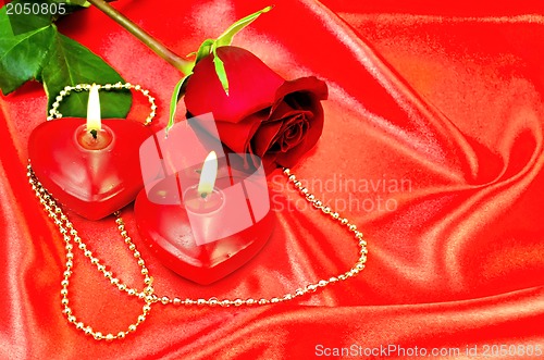 Image of Heart of a candle with a rose on a red silk