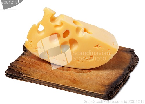 Image of Piece of cheese on old wooden kitchen board