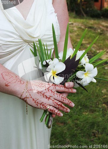 Image of Bride's hand with henna design and fragapani bouquet