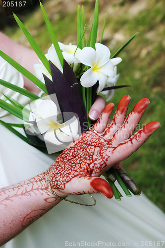 Image of Woman's hand with henna design and fragapani bouquet