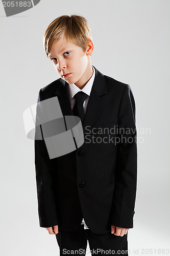 Image of Serious young boy wearing black suit