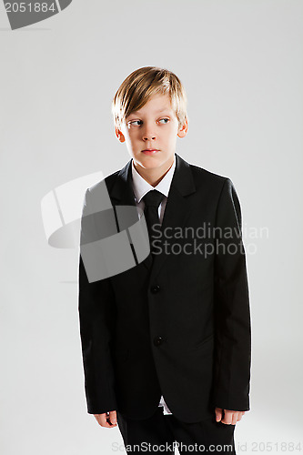 Image of Serious young boy wearing black suit