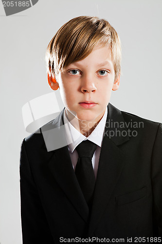 Image of Serious young boy wearing black suit