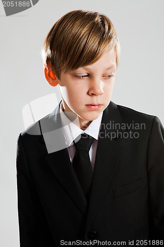 Image of Serious young boy wearing black suit