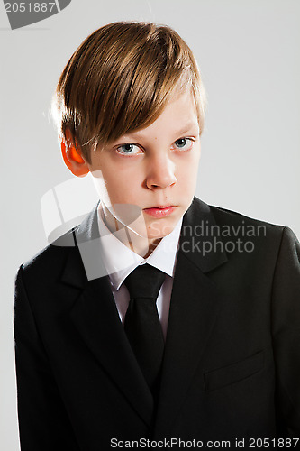 Image of Serious young boy wearing black suit