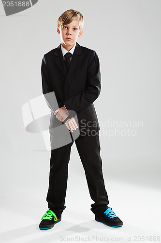 Image of Young boy in black suit and colorful shoes