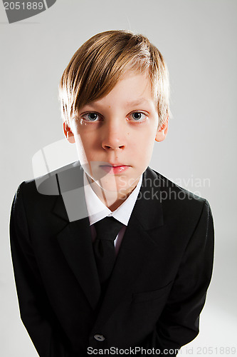 Image of Serious young boy wearing black suit