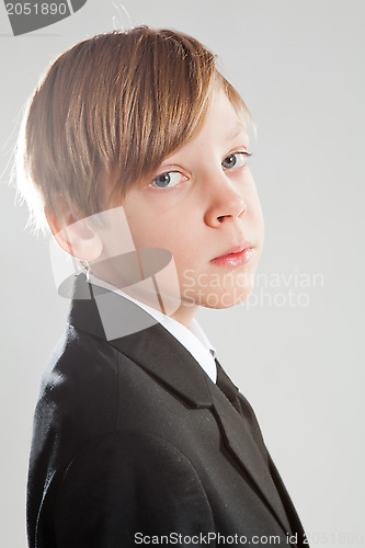 Image of Serious young boy wearing black suit