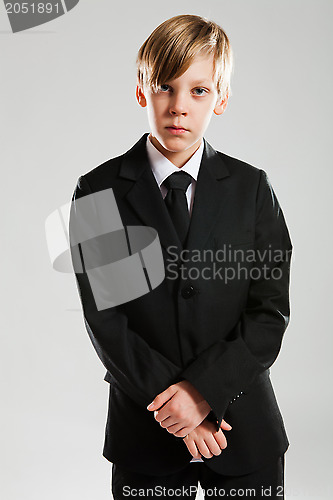 Image of Serious young boy wearing black suit