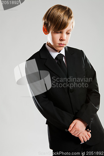 Image of Serious young boy wearing black suit