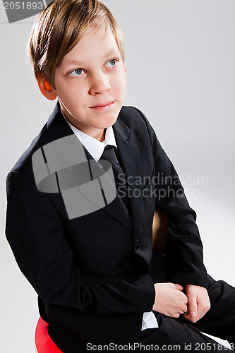 Image of Smiling young boy wearing black suit