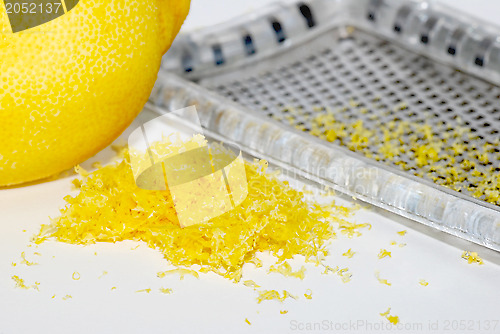 Image of Grated lemon zest with the fruit and grater