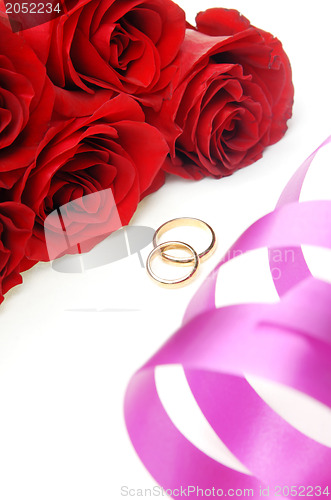 Image of Holiday ribbon and wedding rings with flowers