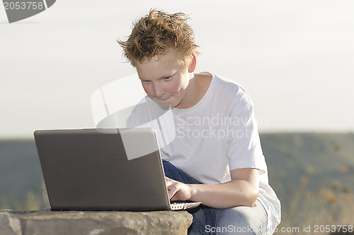 Image of Schoolboy play the game on laptop