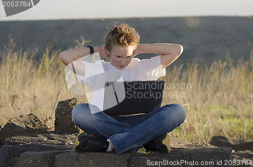 Image of  Teen rest with laptop hold hands behind his head