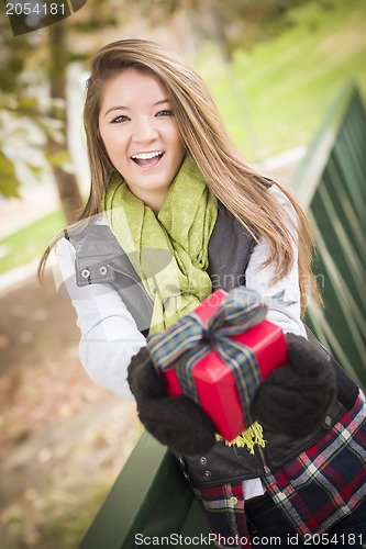 Image of Pretty Woman with Wrapped Gift with Bow Outside