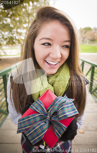 Image of Pretty Woman with Wrapped Gift with Bow Outside